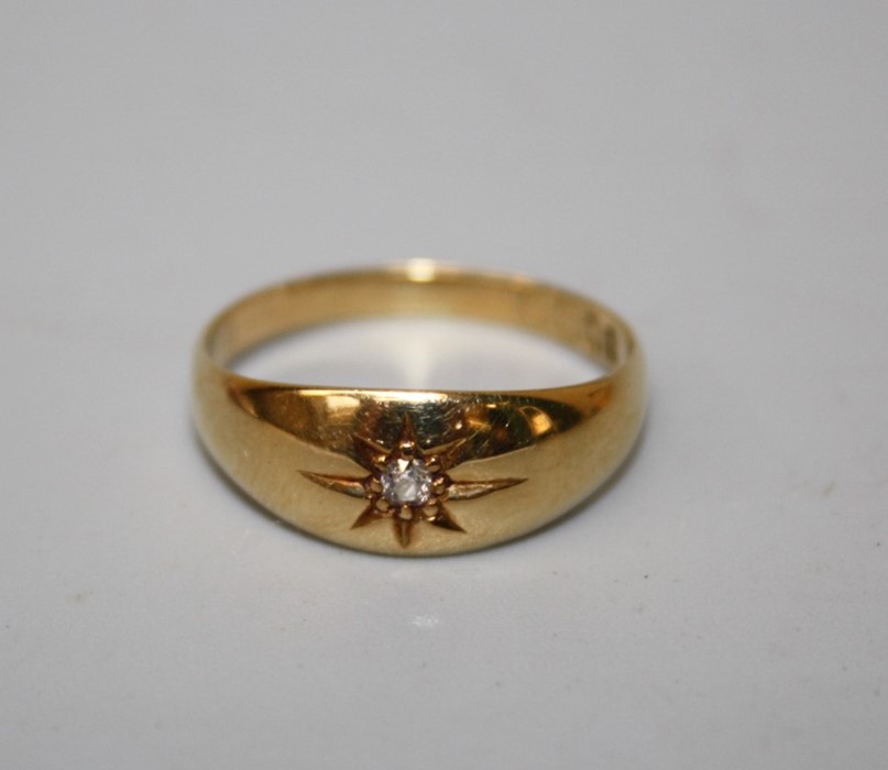 An 18ct gold single stone gypsy set diamond ring to a tapered band. Size P, 3.1g