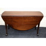 A Geo III oval, mahogany drop-leaf table raised on turned supports with pad. 129cm wide
