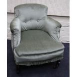 An early 20th century low armchair with stuff-over button upholstery. Raised on turned and inlaid