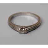 A single stone diamond ring, the brilliant cut diamond set between two bars to a reeded 18ct white