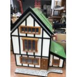 A handmade dolls house in the form of a timbered cottage, mid-20th century, hinged opening revealing