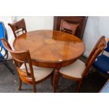 A contemporary teak veneered dining table and set of four chairs with drop in seats, the table is