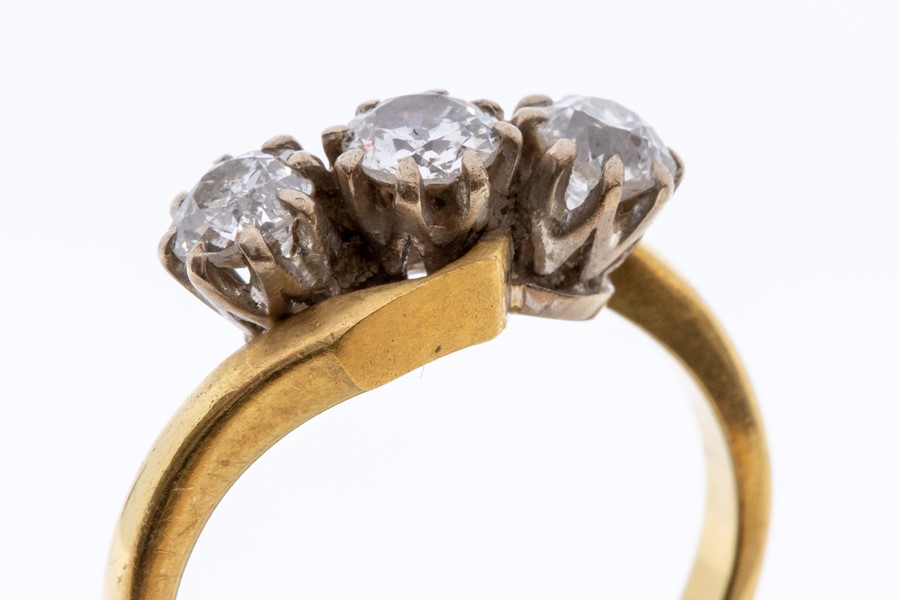 A three stone diamond 18ct gold cross over ring, comprising three claw set old cut diamonds with a - Image 2 of 2