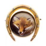 A late Victorian brooch with central enamel fox mask, within a heavy yellow gold horse shoe mount,
