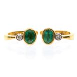 A pair of emerald and diamond 18ct gold earrings, comprising oval rub over set diamonds weighing a