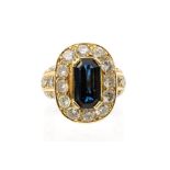 A sapphire and diamond 18ct gold cluster ring, the claw set elongated emerald cut sapphire, weight