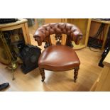 A late Victorian mahogany club chair with a leather deep buttoned back, sprung seat, turned front