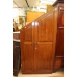 An Edwardian mahogany wardrobe, of sloping design, panelled front