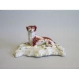 A Staffordshire recumbent Setter on a Scrolled base Date circa  1860 Size  18.5cm diam  9.5cm high
