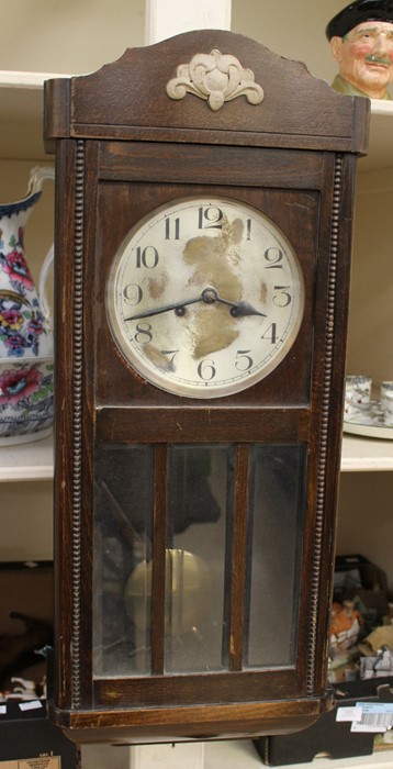 An early 20th Century oak wall hanging box clock, having an eight day movement and a silvered dial