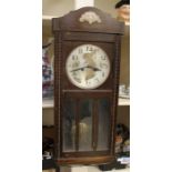 An early 20th Century oak wall hanging box clock, having an eight day movement and a silvered dial