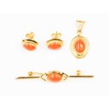 An 18ct gold and coral pendant, set with an oval coral to the centre along with a matching pair of