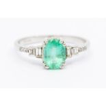 An 18k white gold emerald and diamond ring, the oval-cut emerald approx 1.53ct, ring size R1/2,