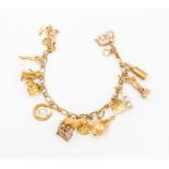 A 9ct gold charm bracelet comprising a fancy link chain with fifteen charms including a windmill,
