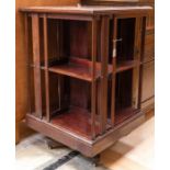 An Edwardian mahogany revolving bookcase, of two-tier form, the top with inlaid marquetry
