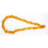 A butterscotch amber necklace, comprising irregular shaped chips, measuring from approx. 9mm - 17mm,
