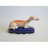 A Staffordshire Greyhound   laying on a cobalt blue base Pen Holder Date circa 1860 Size  18cm diam