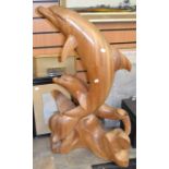 A contemporary hardwood sculpture of leaping dolphins above the waves, height 90cm. Condition: minor