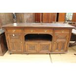 An Edwardian oak sideboard, having three drawers to top, two large doors to sides and two smaller