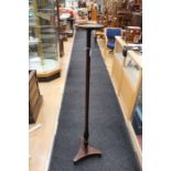 An early 19th Century mahogany torchere, having a dish shaped top, turned and reeded column and