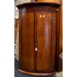 A George III oak and mahogany bow fronted corner cupboard