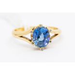 A sapphire and diamond 18ct gold ring, comprising an oval natural blue sapphire set to the centre,
