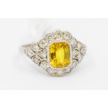 A yellow sapphire and diamond cluster platinum ring, the central octagonal sapphire weighing