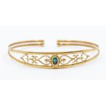 A yellow metal ladies bangle set with an opal to centre and a pierced surround, 5.06 grams approx