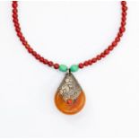 A 20th Century amber and white metal pendant necklace, the pendant formed of a piece of butterscotch