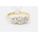 An 18ct gold and diamond three-stone ring, the central old-cut stone approx 0.75ct, flanked by two