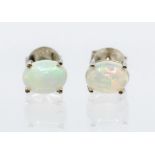 A pair of white opal and silver studs, oval opal set in four claw mounts, size approx  7 x 5mm, post