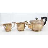 An Art Deco three piece silver tea service comprising teapot, sugar bowl and milk jug, with fluted