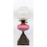 A late Victorian glass and cast table oil lamp with Art Nouveau etched shade, pink glass oil