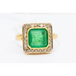 An emerald and diamond square cluster ring, the square-cut collet set emerald approx 8.6mm x 8.6mm x