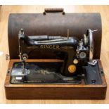 A Singer Sewing machine complete in its wooden case.