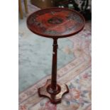 A red lacquered pedestal wine table, with black decoration on a red ground, the turned column