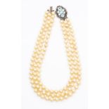 An early 20th Century faux pearl three strand necklace with silver mounted clasp with feather