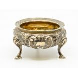 A Russian 84 standard circular silver salt, chased with raised floral decoration on three shell