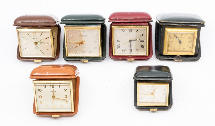 Six small leather cased travel clocks, the Swiss eight day movements in square cases, varying