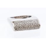 A diamond and 18ct white gold pave set ring, the curved high set form pave set with nine rows of