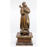 A carved wooden figure of a Monk. Mounted on a wooden plinth. Painted. Some old worm damage.
