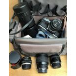 A collection of assorted cameras and lenses to include: Sony Handycam, Olympus OM-10 camera body and