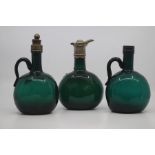A pair of English green glass decanters, mid 19th Century, of bottle form with plain loop handles