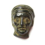 Medieval Face Mount.  Circa 13th-14th century AD. Copper-alloy, 3.54 grams. 18.43 mm. A stunning