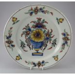 A large eighteenth century tinglazed earthenware delft charger, c.1750-80. It is boldly decorated in