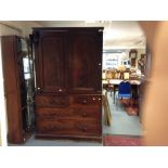 An early Victorian mahogany linen press, fitted with two doors enclosing five sliding shelves, the
