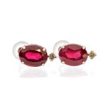 A pair of ruby and diamond 18ct white gold earrings, comprising faceted oval rubies claw set with