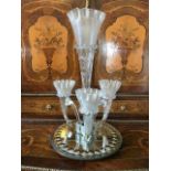 A late Victorian clear glass four trumpet epergne, circa 1880, pincered wavy rims, circular mirrored