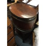 A George III mahogany and brass bound wine cooler, circa 1770, of oval form, fitted with carrying