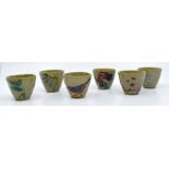 Moorcroft: A set of six eggcups decorated with flowers, fish, birds and butterflies on a green